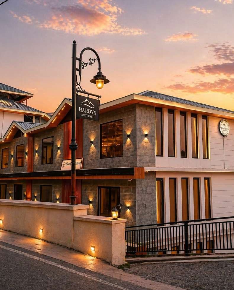 Hardys Retreat facade at sunset — warm golden light on stone exterior with mountains behind