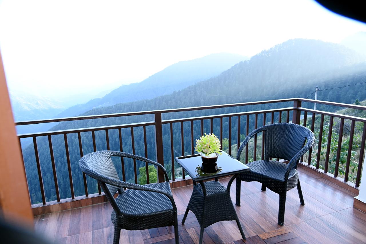 Private balcony seating with pine forest and mountain view at Hardys Retreat Chail