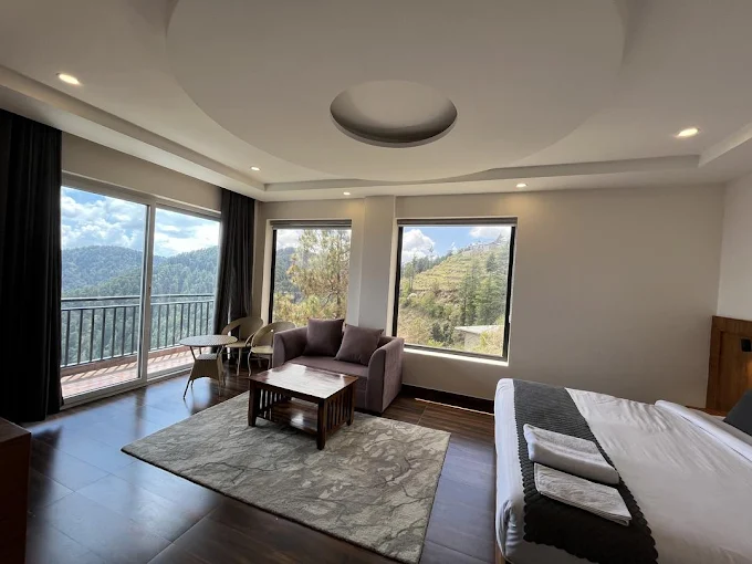 Spacious suite with lounge seating and mountain-view windows at Hardys Retreat
