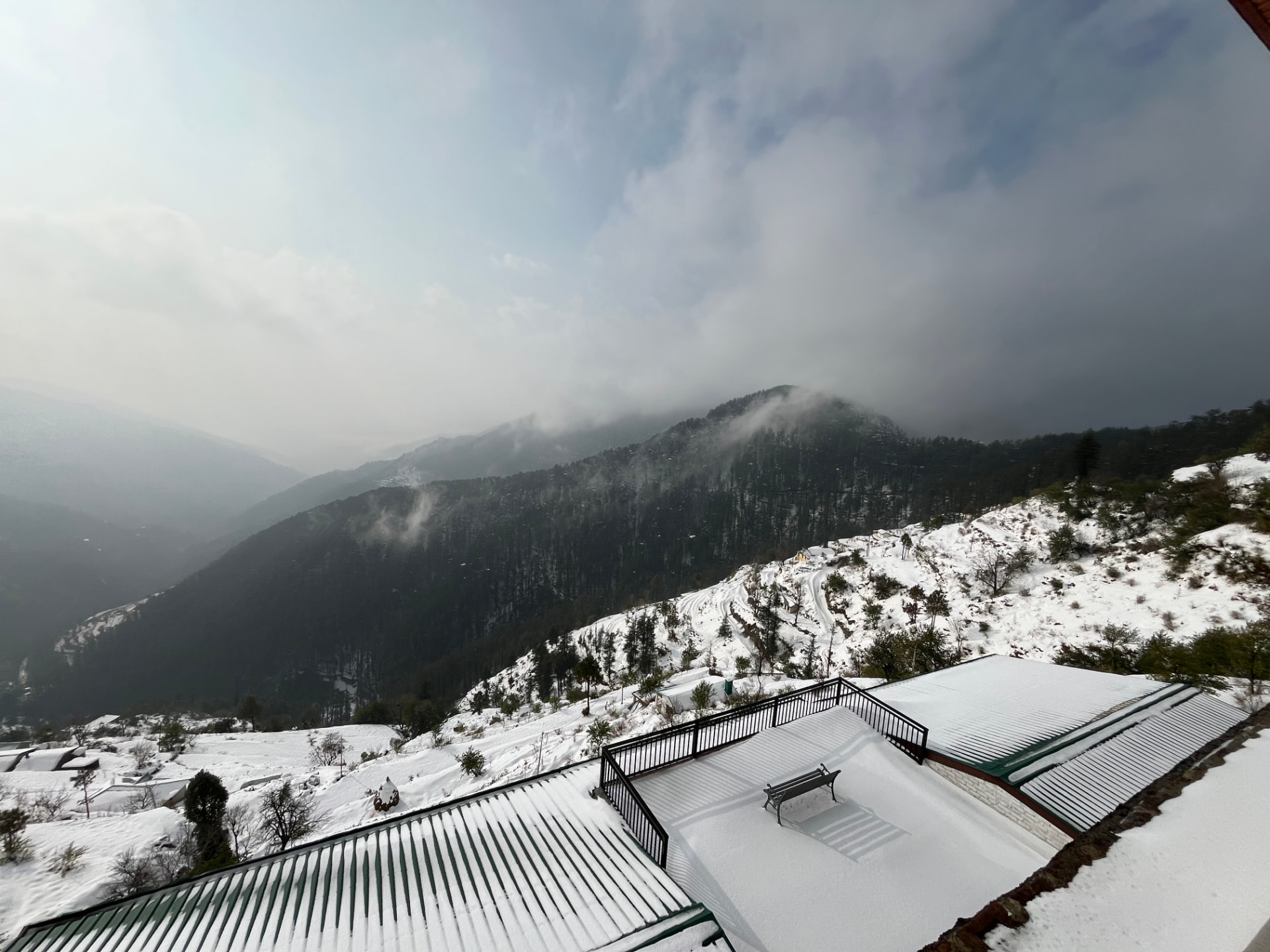Snow-covered rooftop terrace and Himalayan valley view at Hardys Retreat Chail in winter